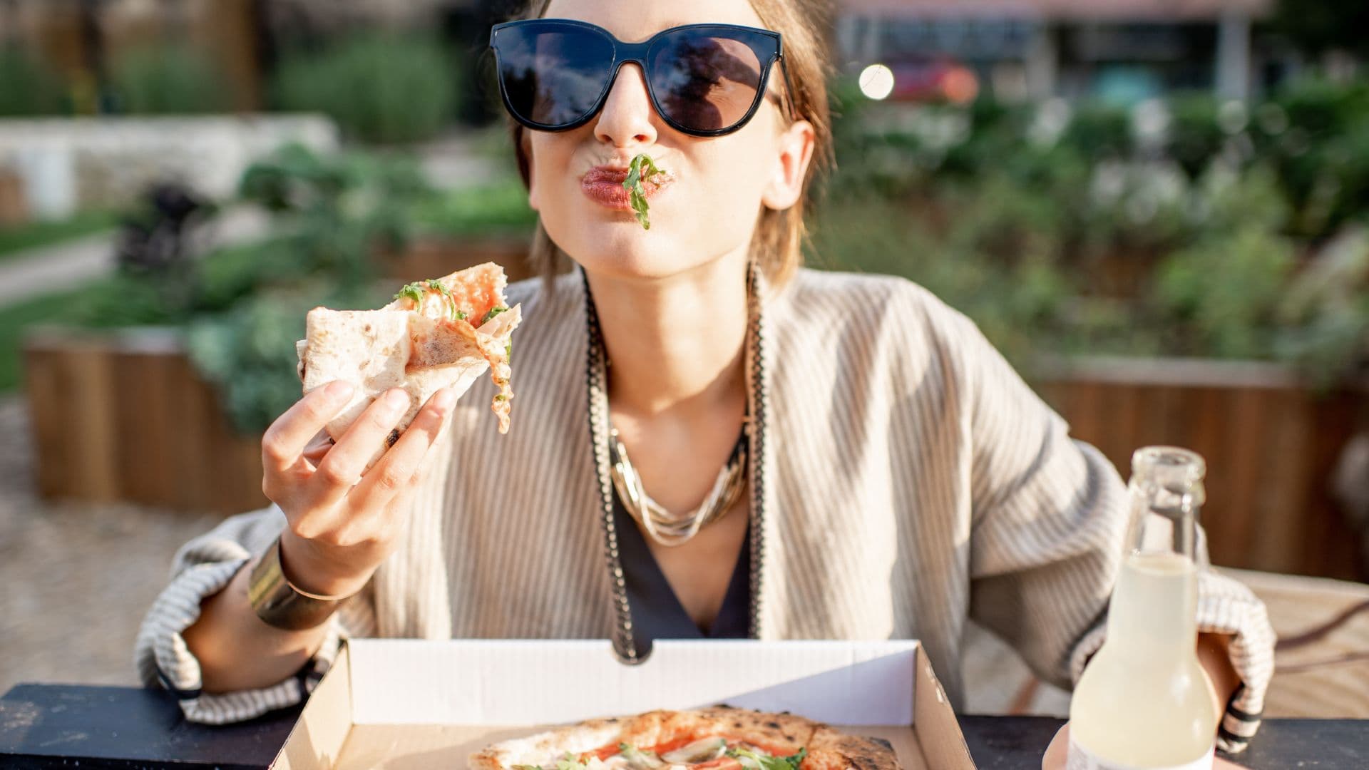 Eine entspannte Frau isst Pizza - Klicke hier um den Essverhaltenstest zu starten